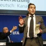 BrItish comedian known as Lee Nelson holds banknotes in front of FIFA President Blatter at a news conference after the Extraordinary FIFA Executive Committee Meeting at the FIFA headquarters in Zurich
