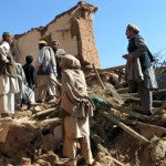 Afghans sift through the rubble of houses destroyed by an earthquake in Sherzad district of Nangarhar province
