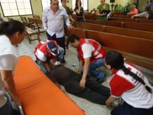  Los jóvenes de la Cruz Roja  atienden a un señor epiléptico dentro de una iglesia.