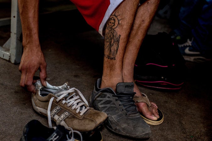Un hombre se probó zapatos en el comedor antes de continuar su trayecto. Credit Tomás Munita para The New York Times.