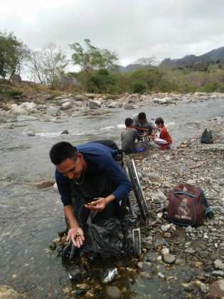 Hondureños en silla de ruedas buscan piedras en el río