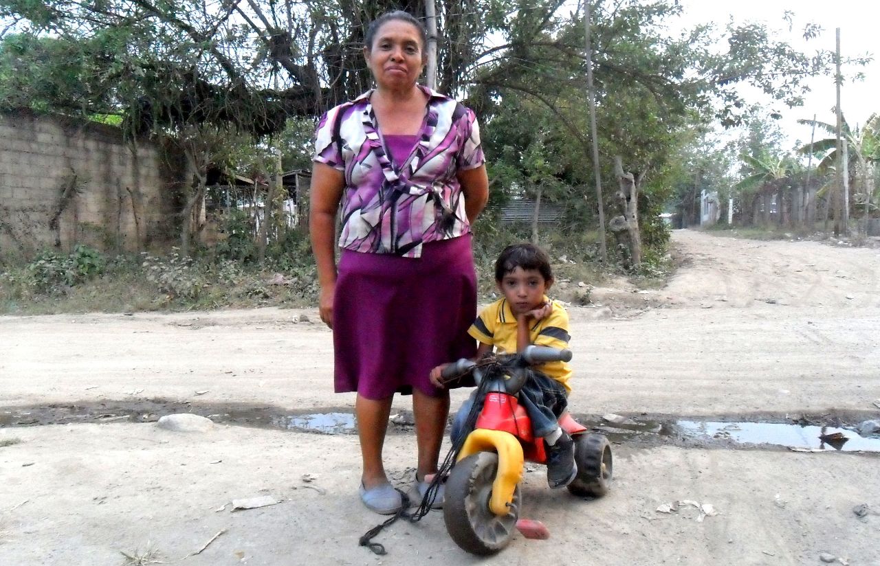 Doña Dina y su hijo en una moto de juguete, debido a que se cansa muy rápido