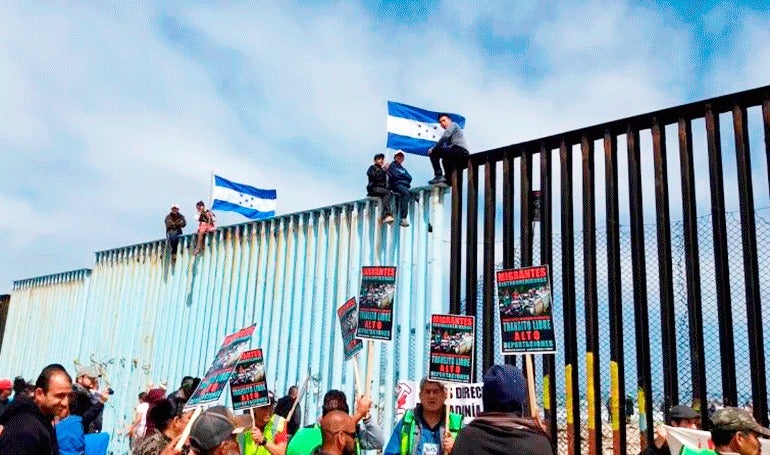 Migrantes llegan al muro que divide Mé­xico y EE.UU.