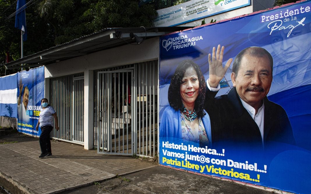 Un hombre pasa junto a una pancarta que promueve la candidatura del presidente de Nicaragua Daniel Ortega y su esposa y compañera de fórmula Rosario Murillo.