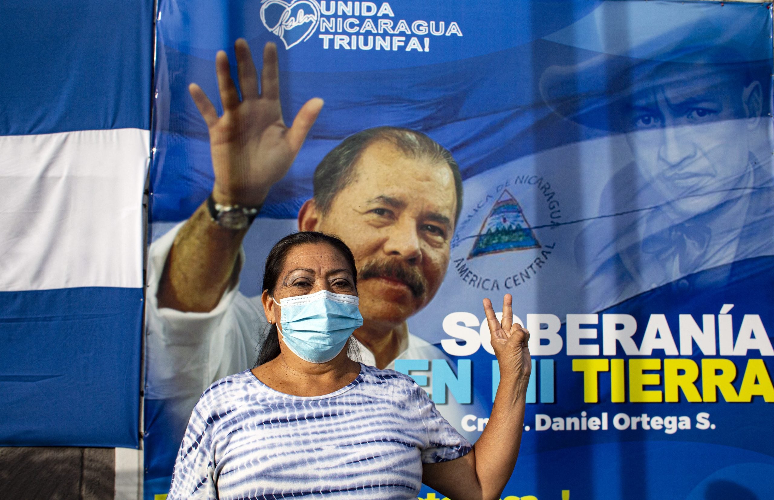 Una mujer gesticula frente a una pancarta que promueve la candidatura del presidente de Nicaragua, Daniel Ortega, en Managua.