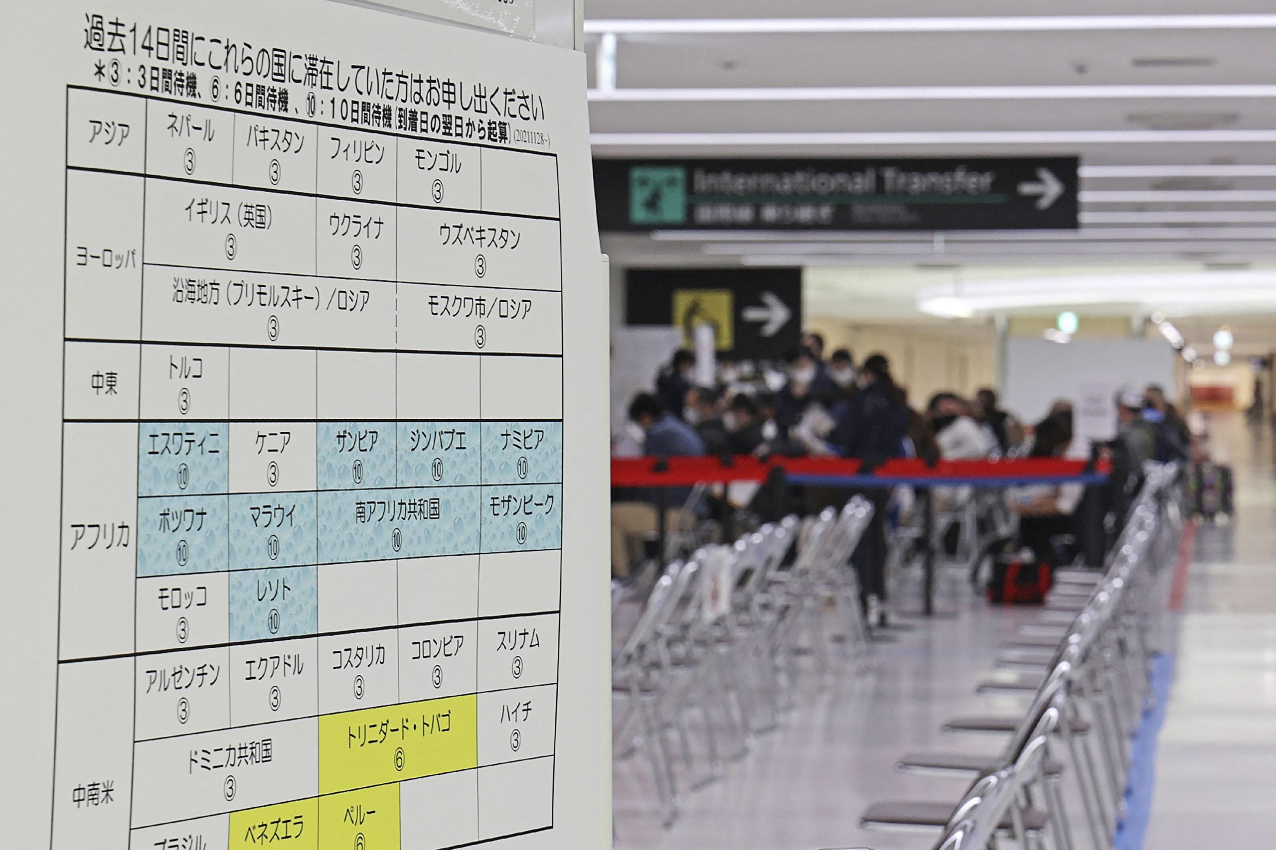 Viajeros esperando ser llevados a cuarentena en un aeropuerto asiático.