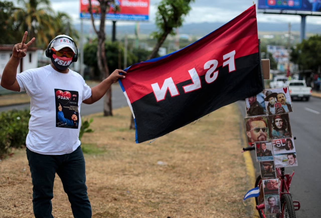 Un simpatizante del presidente de Nicaragua, Daniel Ortega, muestra una bandera del partido Frente Sandinista de Liberación Nacional (FSLN) en Managua.