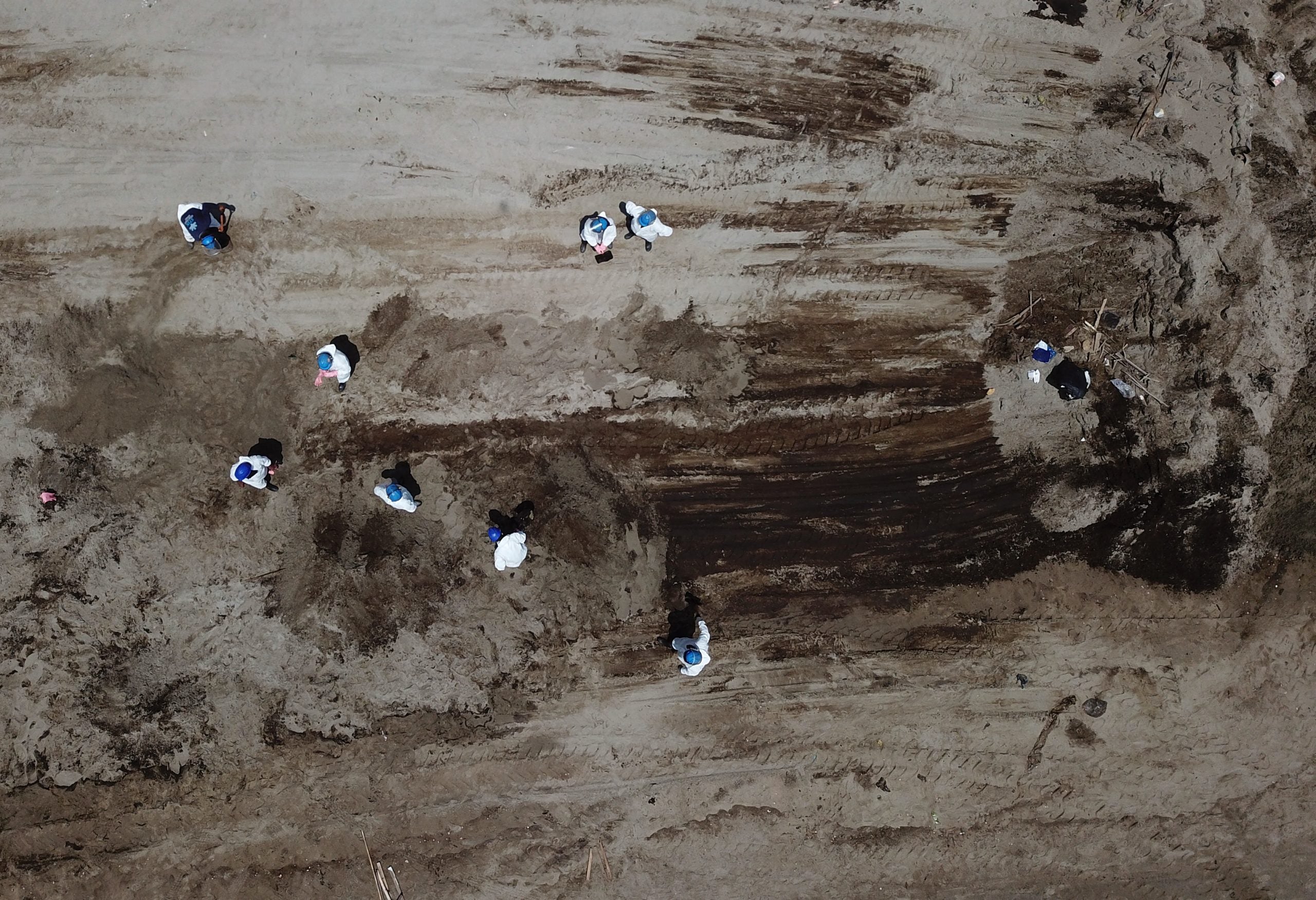 Vista aérea que muestra el trabajo de los equipos de limpieza para retirar el petróleo de una playa en la provincia peruana de Callao.