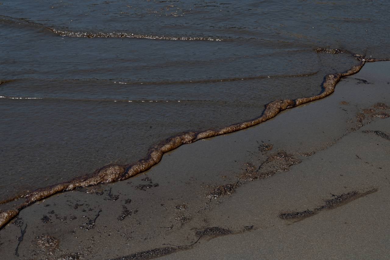 Lavado de petróleo en tierra en una playa en la provincia peruana de Callao el 17 de enero de 2022.