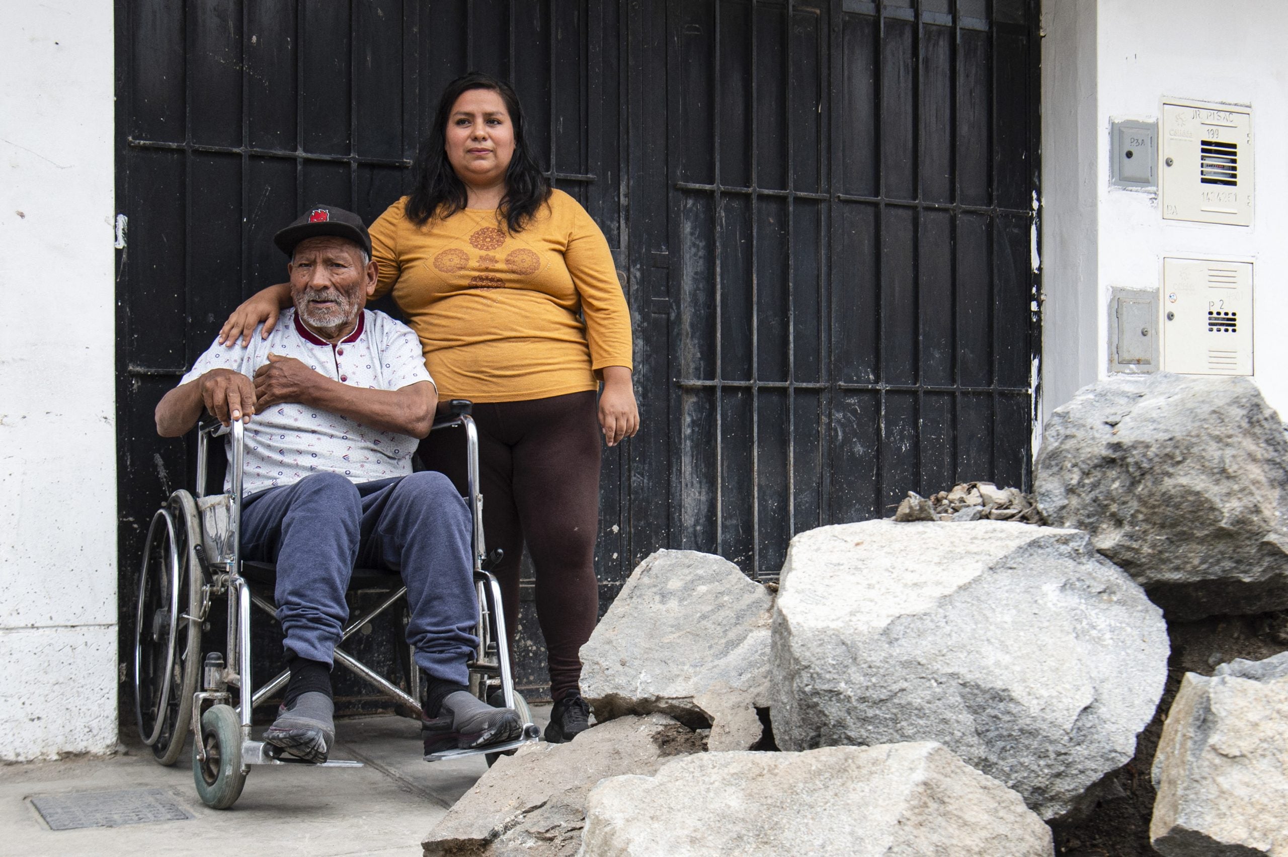 Daysi Falcón López, de 34 años, posa para una foto con su abuelo afuera de su casa en el distrito Independencia.