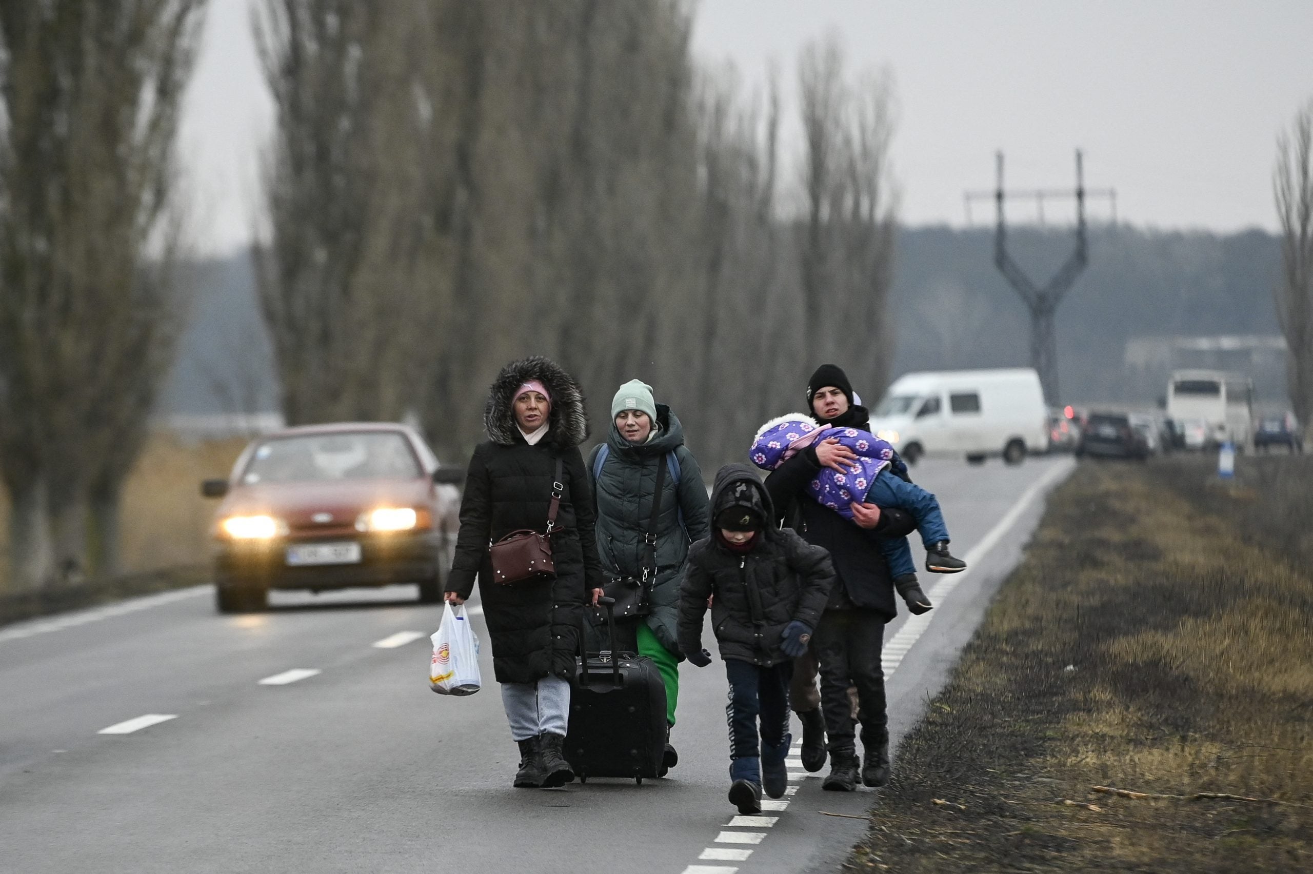 Refugiados de Ucrania caminan por una carretera después de cruzar el puesto de control fronterizo entre Moldavia y Ucrania.