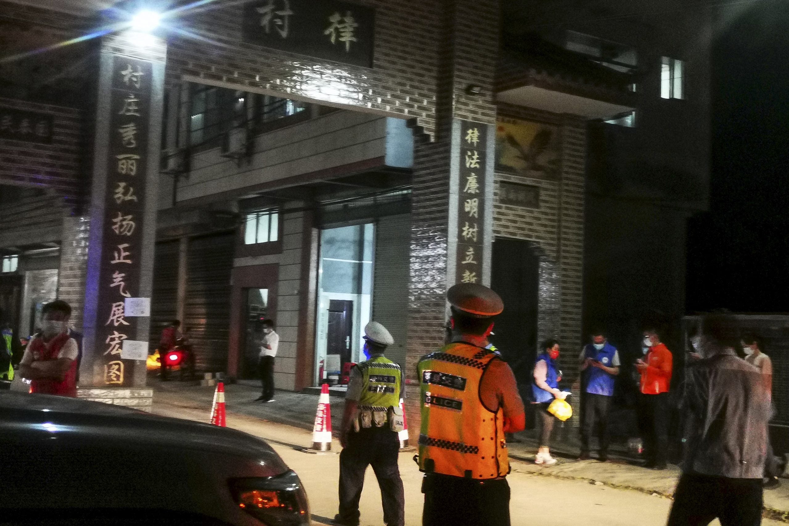 Oficiales de policía montan guardia en la entrada de un pueblo que conduce al lugar de un accidente aéreo en el condado de Tengxian.