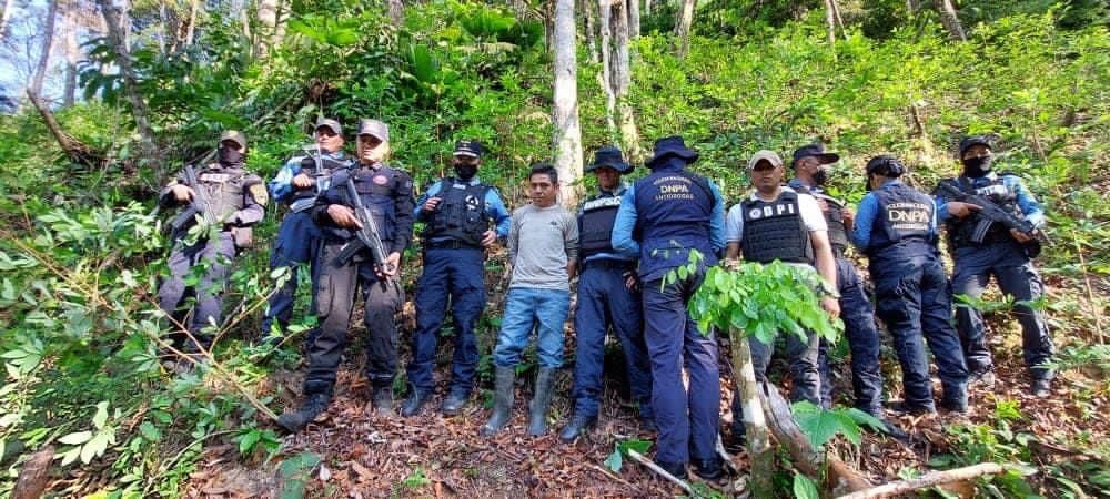 Autoridades que participaron en la operación y el detenido en la zona montañosa.
