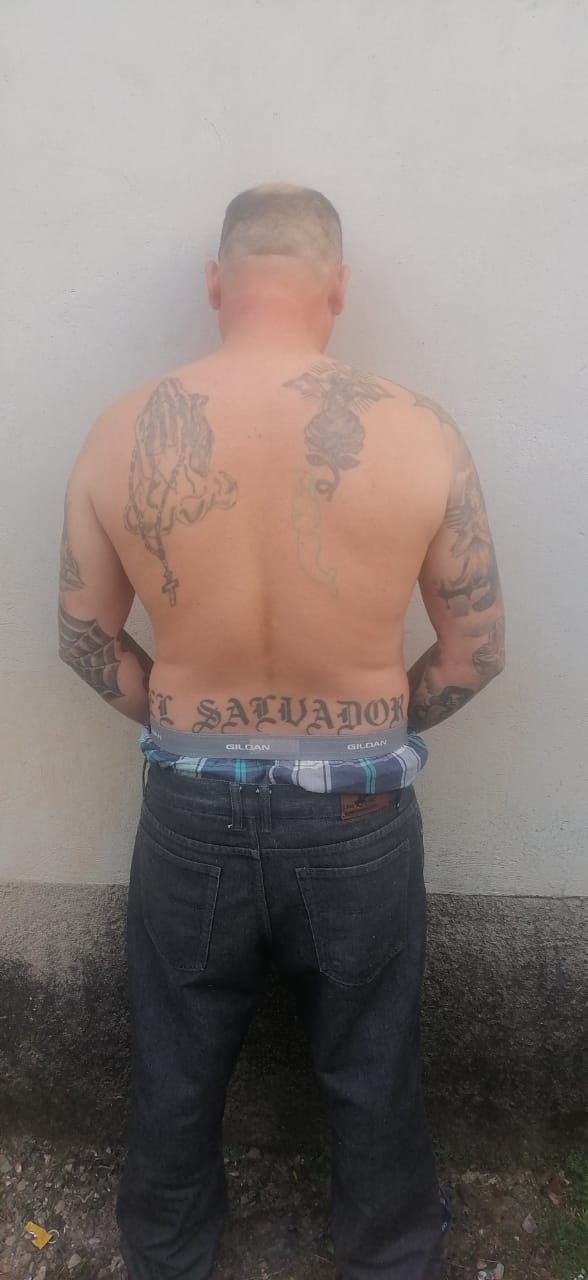 En su espalda tiene un tatuaje que dice El Salvador, otro de una rosa y otro de unas manos con un rosario.