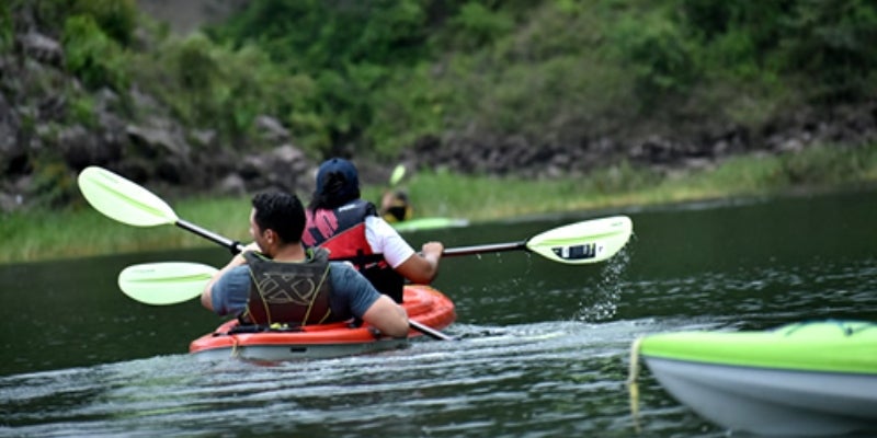 Cientos de personas recorren en lago en kayak. 