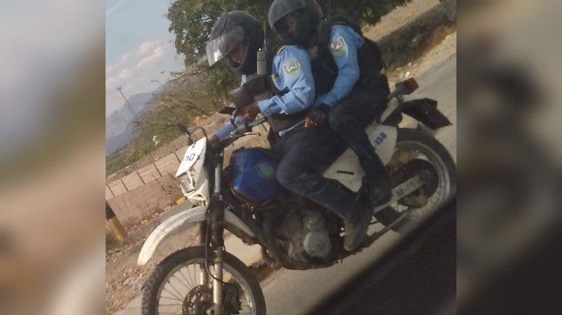 policía en motocicleta y usando celular