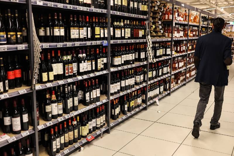 Un cliente pasa junto a botellas de vino exhibidas en un supermercado en Toulouse, suroeste de Francia.