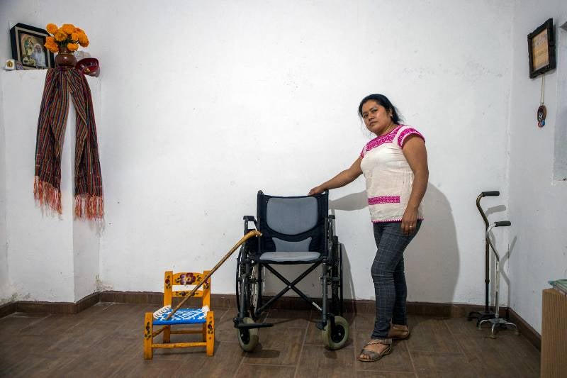 Patricia Pérez Hernández, nieta de Mamá Coco, posa junto a la silla de ruedas de su abuela en su casa.