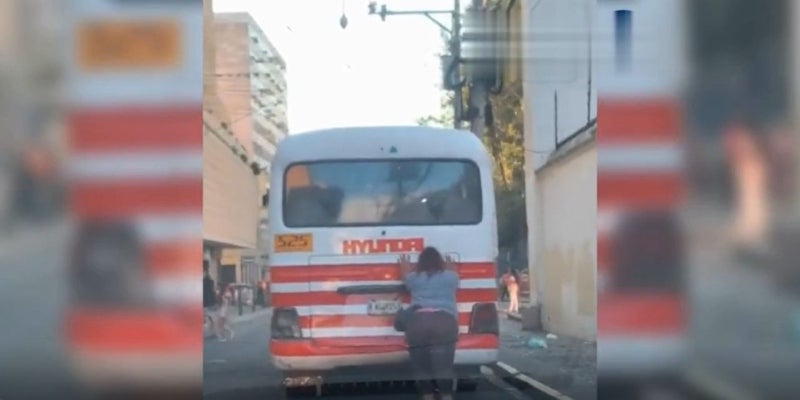 Fuerte mujer empuja bus en la capital de Honduras