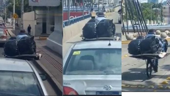 A bordo de su bicicleta, hombre respeta las señales de tránsito en TGU