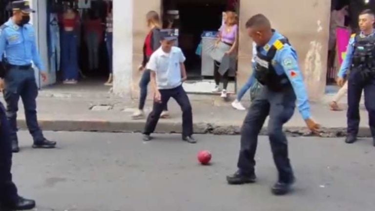 Policías juegan pelota con niños