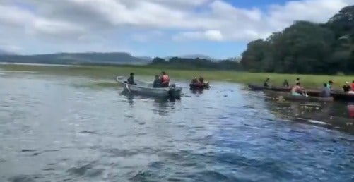Varias personas buscan al pescador en lanchas. 