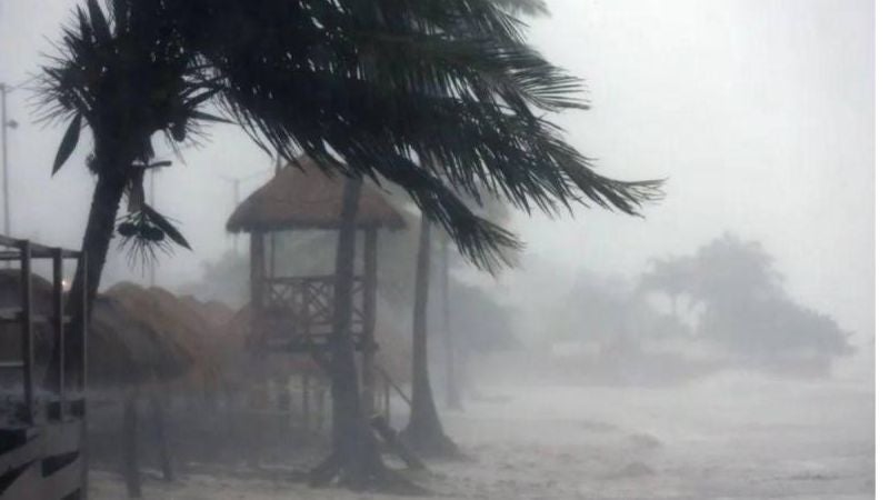 Hombre se sube en un kayak en su casa inundada por el huracán Helene