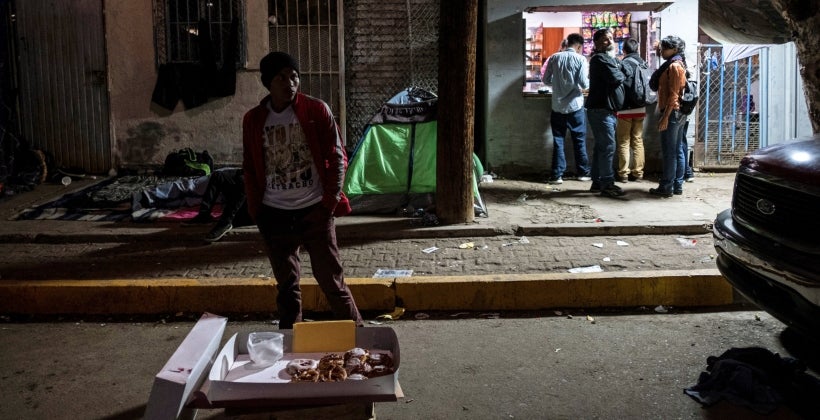 Un migrante hondureño vende donas afuera de un albergue temporal en Tijuana, estado de Baja California, México. (Foto: AFP)