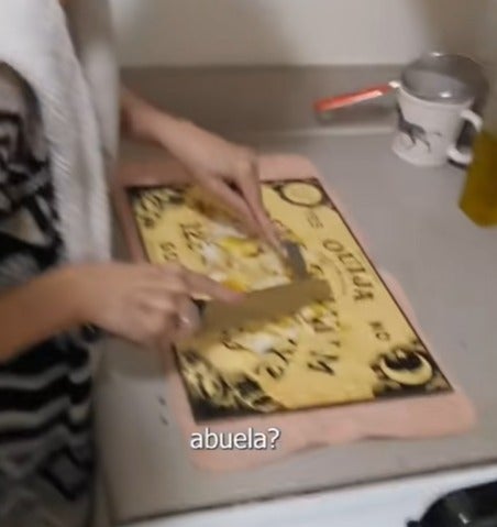 abuela corta carne sobre una Ouija