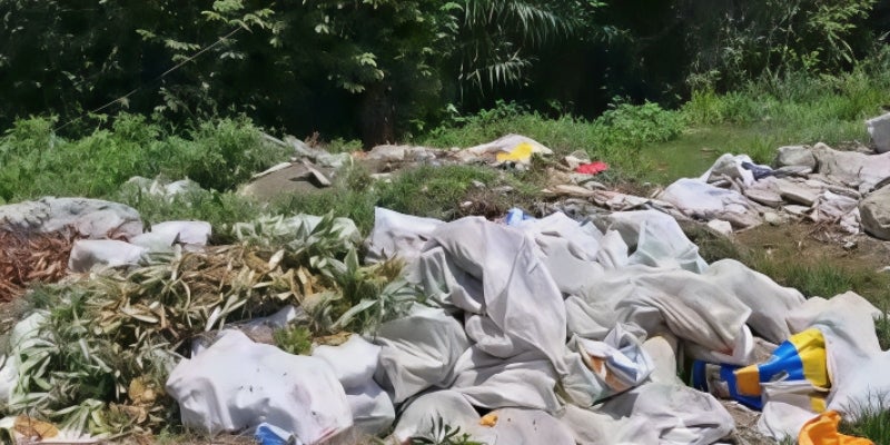 Varios sacos de basura han sido arrojados a la orilla de la carretera.