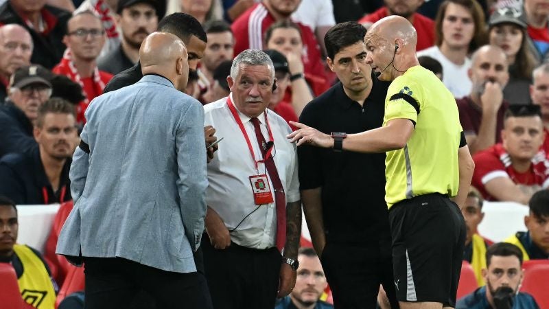 El árbitro inglés Anthony Taylor habla con ambos entrenadores y el responsable de seguridad del estadio después de que un miembro de la multitud gritara insultos al delantero ghanés del Bournemouth, Antoine Semenyo.