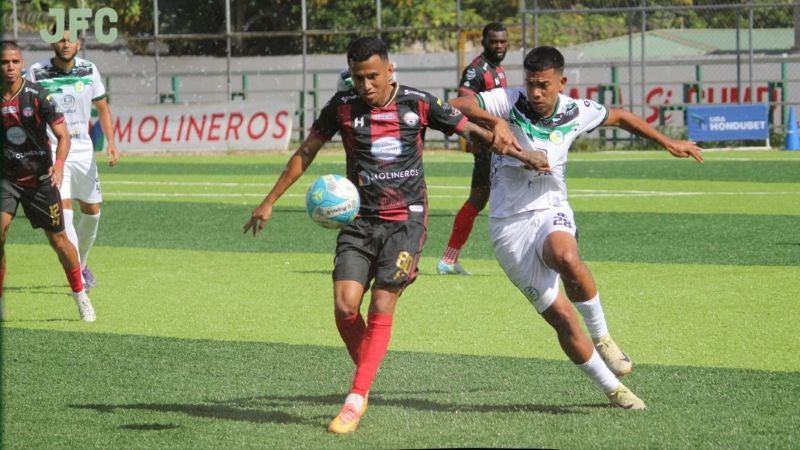 El jugador del CD Choloma, Selvin Guevara, controla el balón presionado por Axel Gómez de Juticalpa FC.