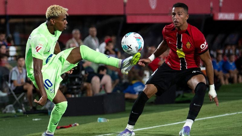 El delantero del Barcelona, Lamine Yamal, y el atacante del Real Mallorca, Mateo Joseph, luchan por el balón.