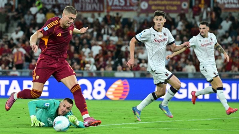 El delantero ucraniano de la Roma, Artem Dovbyk, intenta marcar contra el portero polaco del Bolonia, Lukasz Skorupski.