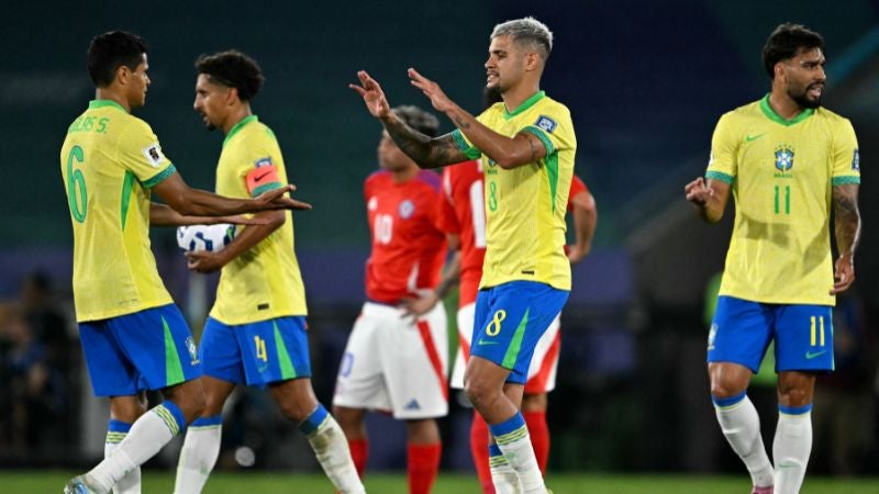 El defensa Douglas Santos y el mediocampista Bruno Guimaraes se saludan al final del partido contra Chile.